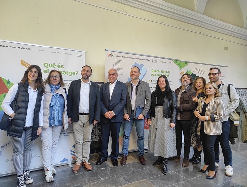 Imagen del acto de inauguración. Aparecen dos paneles de la exposición y delante, el profesorado de geografía y director del centro. El director de la cátedra y la Vicerrectora de Cultura y Sociedad